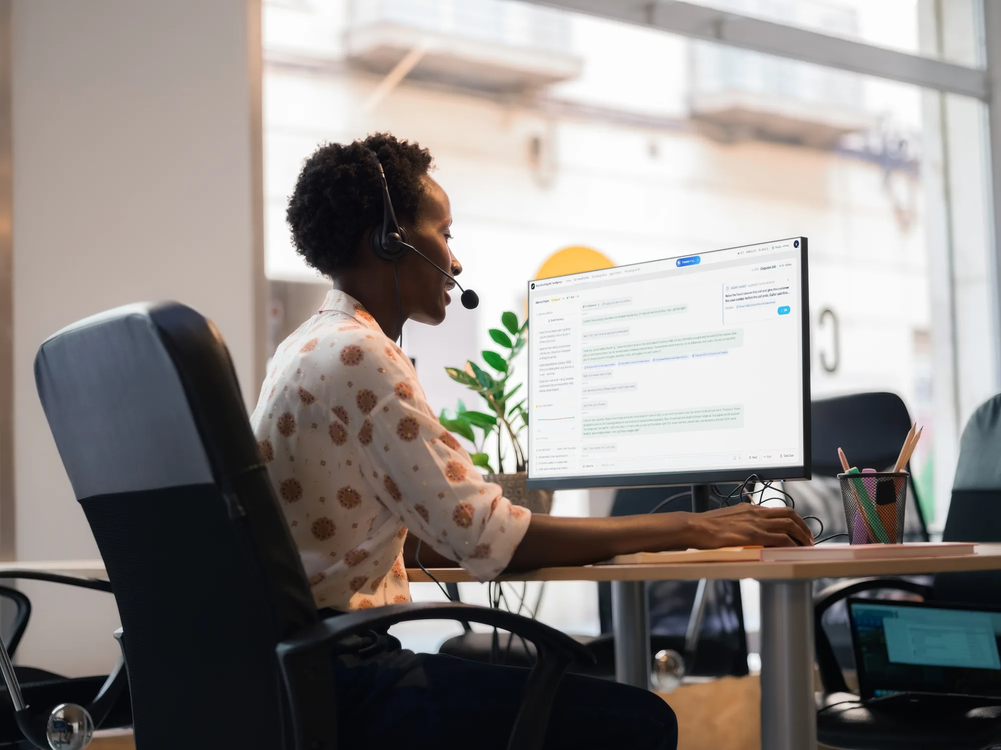 Supervisor with a headset at a desk, the Sanas Supervised AI console on screen